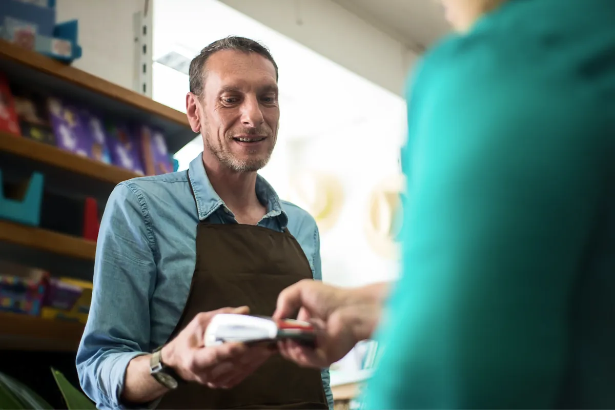 Store owner taking a card payment from a customer
